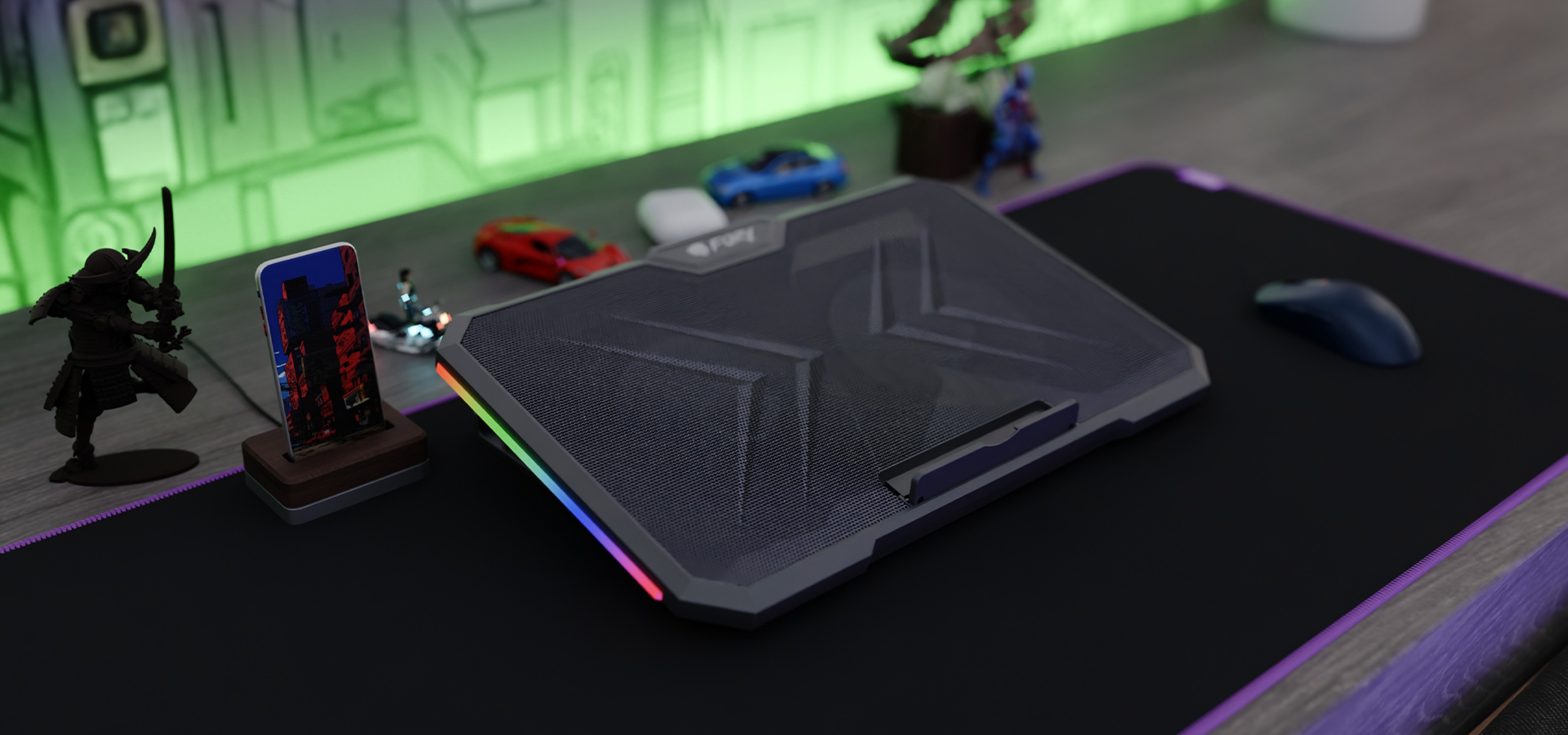 Podkładka chłodząca do laptopa z RGB na biurku z myszką i małymi figurkami dekoracyjnymi.